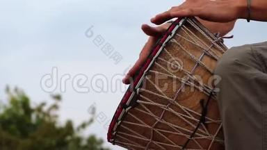 一个人在蓝天上演奏非洲舞的鼓。 创造力，休息和放松.. 民族乐器对抗天空
